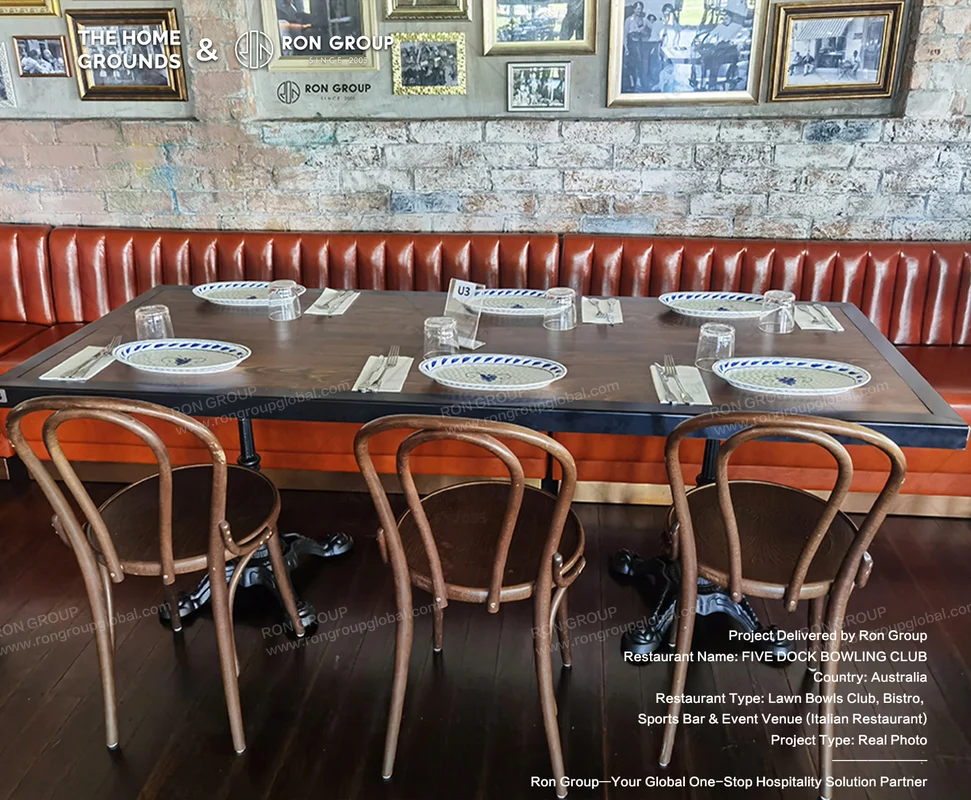 Rustic wooden table set with blue patterned plates bentwood chairs and red leather booth