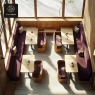 An overhead shot of a modern dining room featuring purple booths and wooden tables.