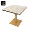 A bistro table with a dark brown marble top and a black central base.