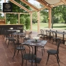 A restaurant terrace with decorative blue tables and black chairs.