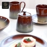 Close-up of a sugar pot and creamer from the deep purple kiln-glazed series, with desserts in foreground.