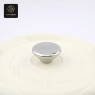 A close-up of the metal knob and 'Success' embossed on the cream-colored dutch oven lid.
