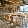 Gold medallion chairs and a long marble table set for a formal event.