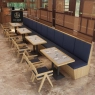Long row of navy upholstered booth seating paired with light wood tables and chairs.