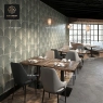 A restaurant with multiple black marble-top round tables and black chairs.