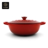 A vivid red, oval enamel cast iron dutch oven with its lid on.