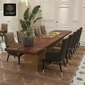 Beige high-back dining armchairs around a long wooden table in a formal dining room.