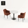 A round stone table with a black base and two brown upholstered chairs.