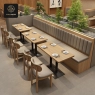 A dining area with beige booths, wooden tables, and matching dining chairs.
