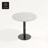 The round white marble table top with a black, single-column base.