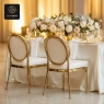 Two gold-framed oval-backed chairs at a beautifully decorated table.