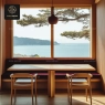 A serene dining area with a long window overlooking a beautiful ocean view.