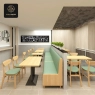 A long green booth and wooden tables with black-base support in a dining hall.