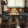 A restaurant interior with blue and green leatherette chairs, and wooden tables.