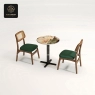 A mosaic round table with a black base and two dark wood chairs with green cushions.