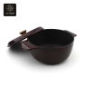 A dark red enamel cast iron dutch oven with the lid propped open, showing the black interior.