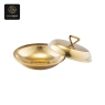 A hammered gold serving bowl, featuring a patterned interior, comes with a matching lid.