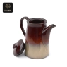 A deep purple kiln-glazed teapot with its lid beside it, showcasing its unique glazed effect.