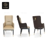 A high-back dining armchair with beige leatherette and patterned dark sides.