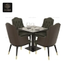 Dark green high-back armchairs with patterned brown sides around a black table.