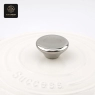 A white enamel cast iron dutch oven with a 'Success' embossed lid and a metal knob.