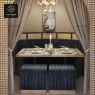 A cozy private dining nook with blue velvet benches, grey curtains, and a mirror on the wall.