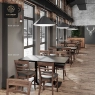 A modern office with a large rectangular table and gray upholstered chairs.