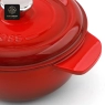 A close-up of the handle and 'Success' embossed lid on a red dutch oven.