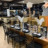 Black Chiavari chairs at a long table with elegant, dark decorations.