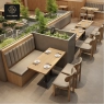 A restaurant with beige booth seating and a central rock garden.