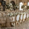 Gold medallion chairs with beige velvet seats, set at a banquet table.
