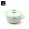 A light green enamel cast iron Dutch oven with its lid on, angled slightly.