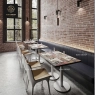 A row of unique pattern tables with white bases and chairs in a restaurant setting.