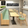 A restaurant's dining area with a long green booth, wooden tables, and matching chairs.