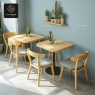 A minimalist dining space featuring round-back wooden chairs and square-top tables.
