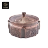 A single hexagonal bronze chafing dish in a rich, reddish hue, adorned with 
