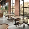 A restaurant setting with multiple Series E wood tables next to large windows.