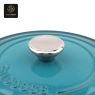 Close-up of the handle and lid of a light blue heart-shaped enamel cast iron pot.