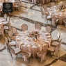 An aerial view of a wedding reception with round tables and white chairs.