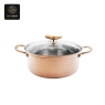 A hammered copper-colored pot with a glass lid and gold handles.