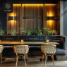 A restaurant with rattan chairs, a long dark booth, and potted plants.