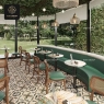 A restaurant with round mosaic tables and a green curved booth.