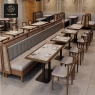 A restaurant with beige booths and chairs, wooden frames, and marble tables.