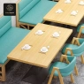Booth seating with light-blue cushions, paired with wooden tables and chairs.