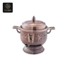 A copper-finished induction cooker with elegant bamboo and floral patterns.