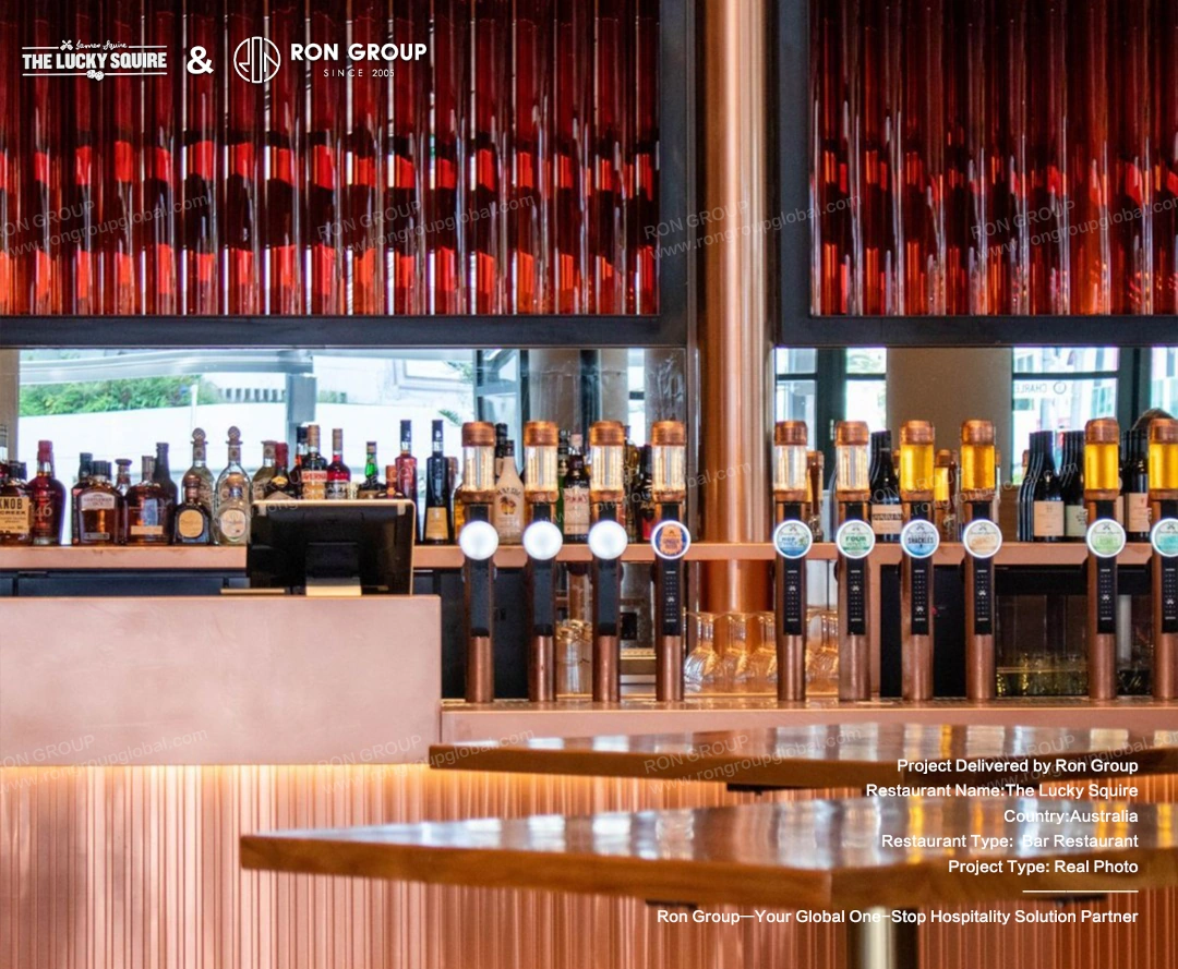 Custom copper beer taps with glowing brand logos lined up at the main bar