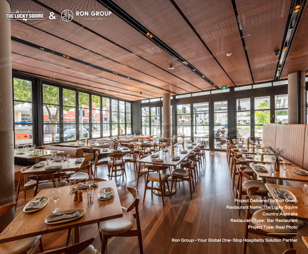 Spacious indoor dining area with natural light, featuring Ron Group's custom wooden tables and chairs