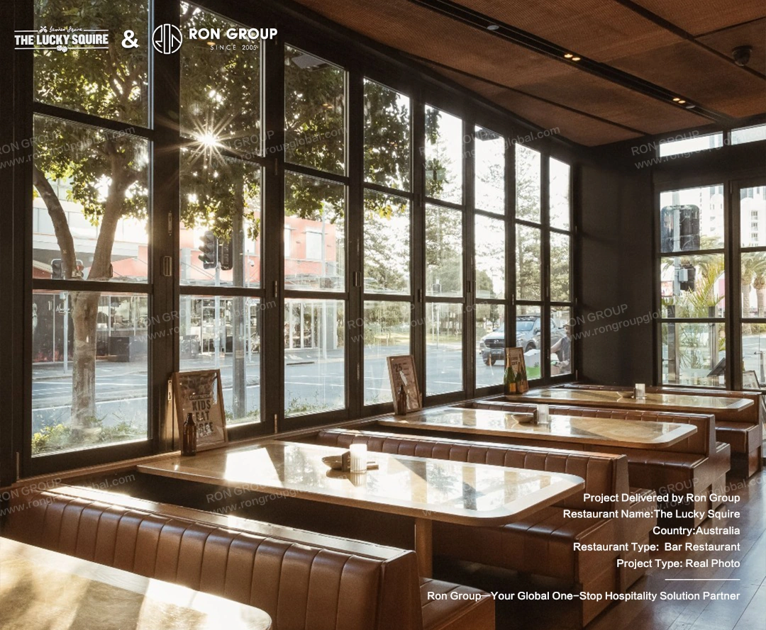 Comfortable vintage-style leather booth seating next to large folding windows