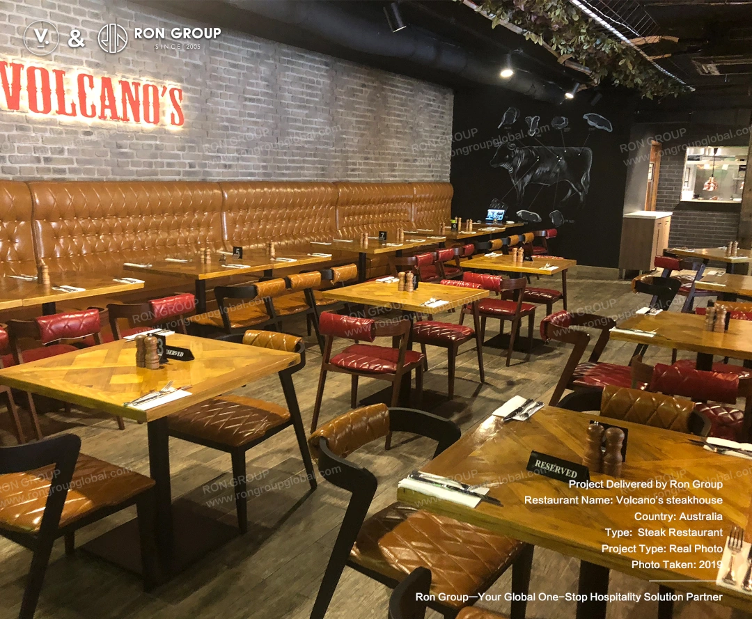 Main dining hall seating arrangement Open dining area with custom tables, leather chairs, and long banquette seating at Volcano's Steakhouse