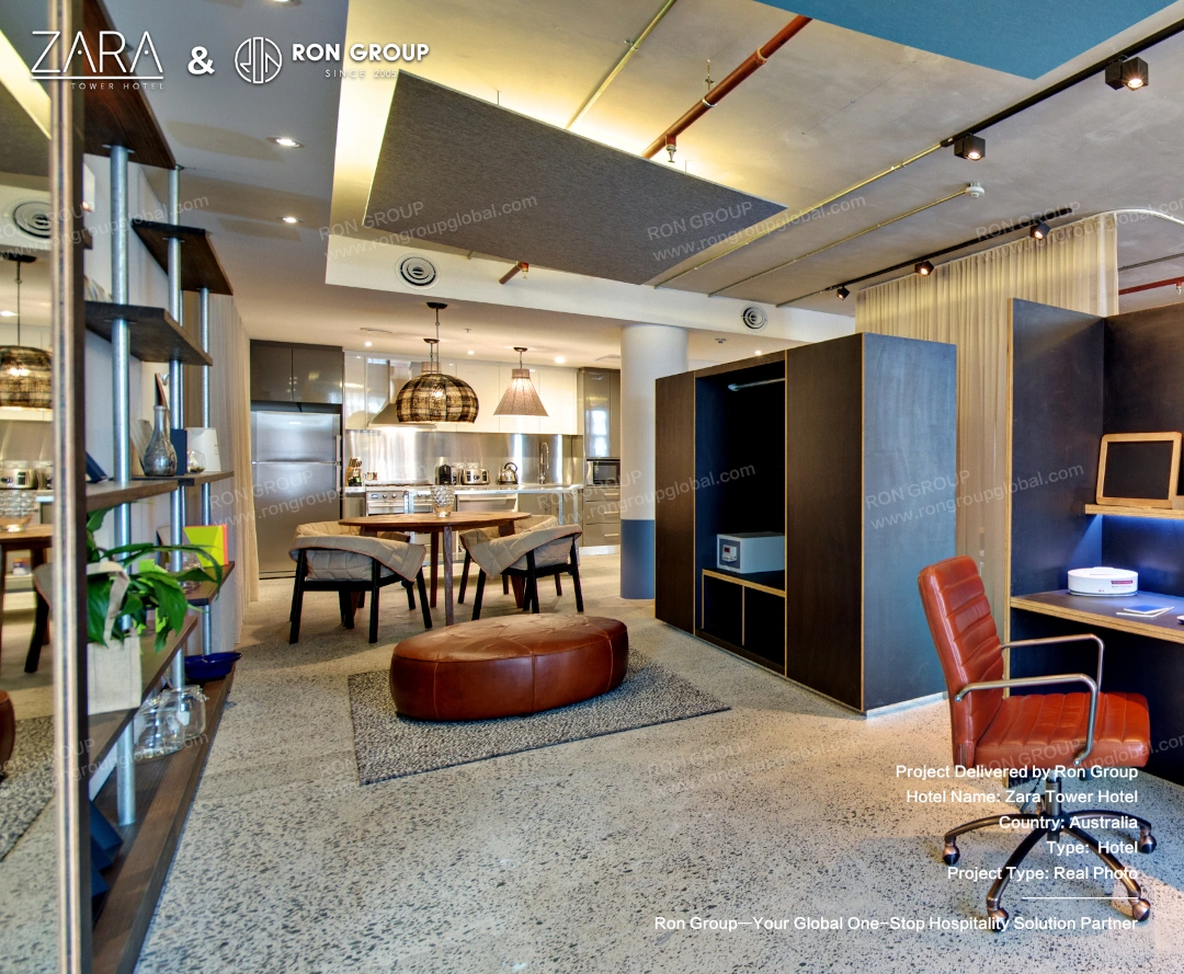 An open-plan view of the SoHo suite showing dining, living, and workspace areas with industrial design elements.